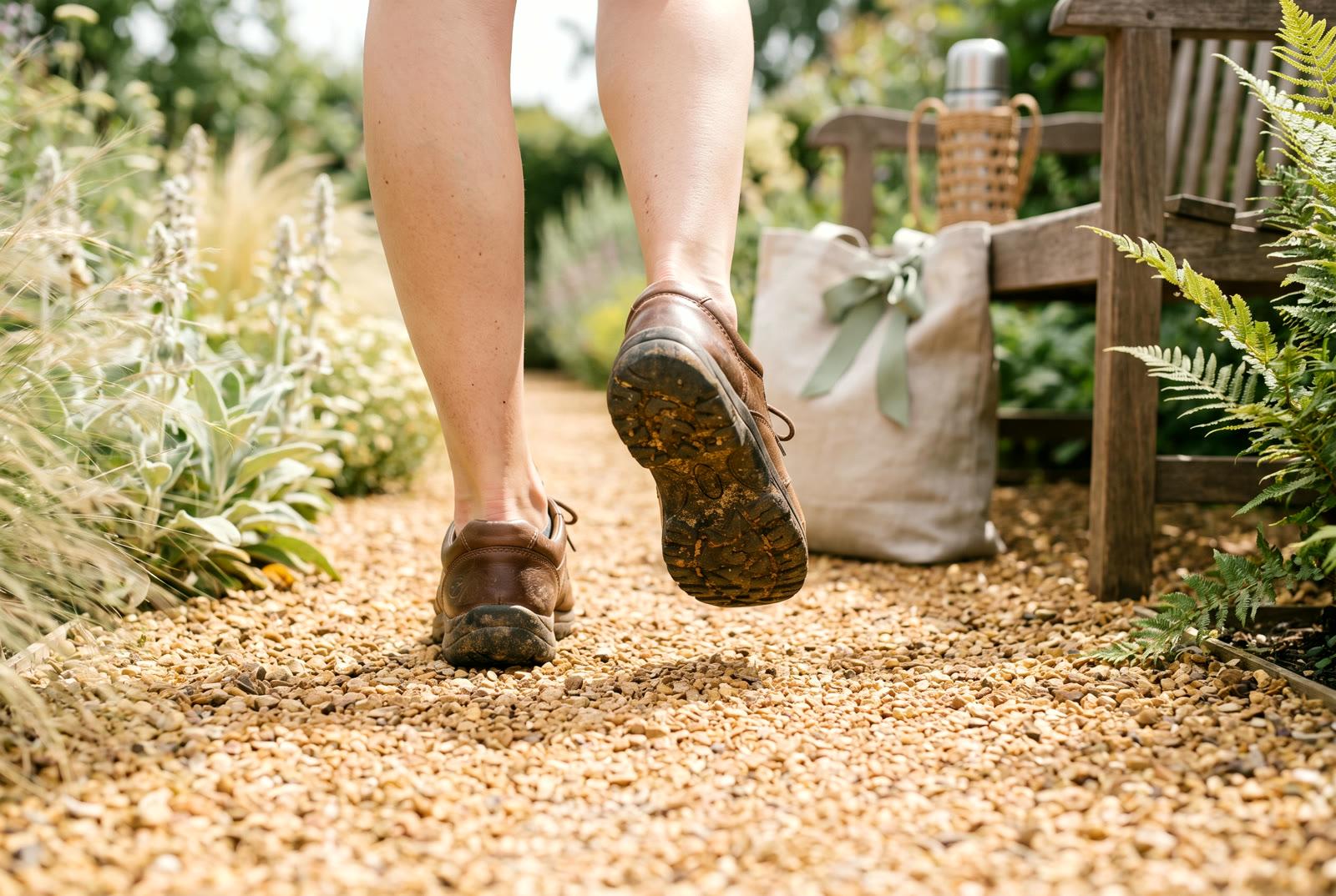 A sunlit path at midday, walking shoes mid-stride